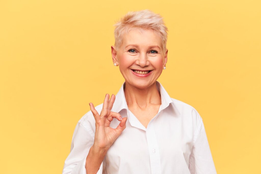 Menopausia, mujer de edad avanzada sonriendo haciendo un ok con su mano